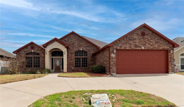 view of front facade with a garage, driveway, and brick siding