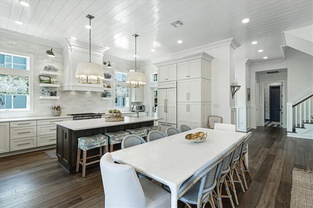 251 Laughter Ln, Port Aransas, TX 78373 - kitchen featuring paneled refrigerator, open shelves, a breakfast bar area, light countertops, and dark wood-style floors