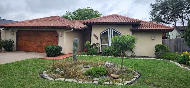 mediterranean / spanish home featuring a front lawn, a tiled roof, an attached garage, and stucco siding