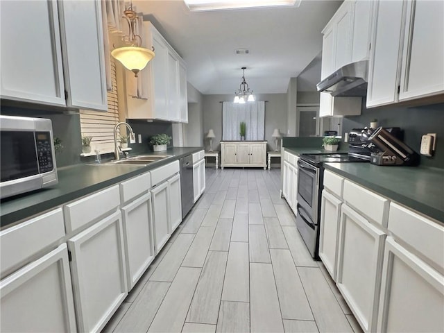 kitchen featuring appliances with stainless steel finishes, white cabinetry, a sink, and extractor fan