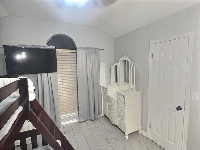 bedroom featuring wood tiled floor and vaulted ceiling