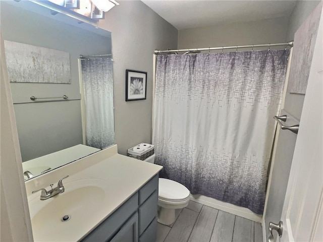 bathroom featuring toilet, vanity, and a shower with curtain