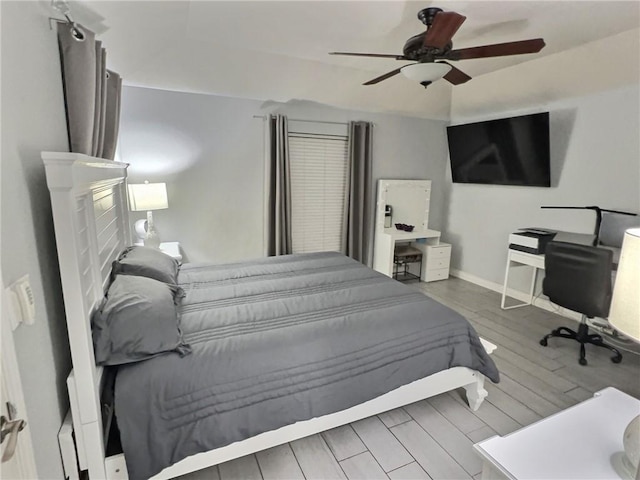 bedroom featuring a ceiling fan, baseboards, and wood finished floors