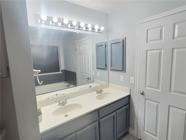 full bath with double vanity, a sink, and a bath