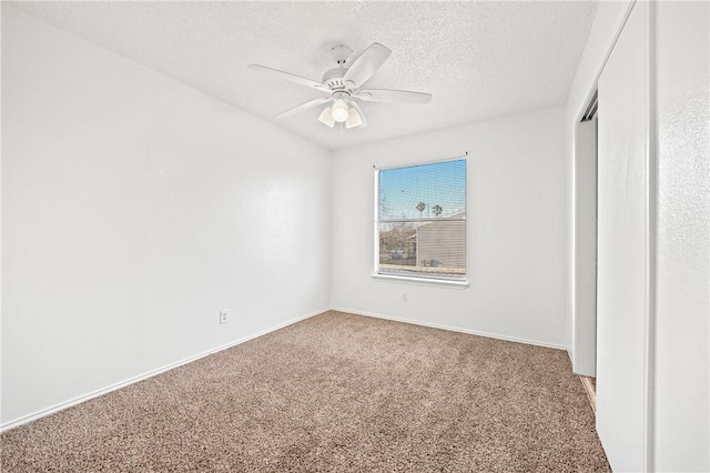 unfurnished bedroom with ceiling fan, carpet floors, a closet, and a textured ceiling