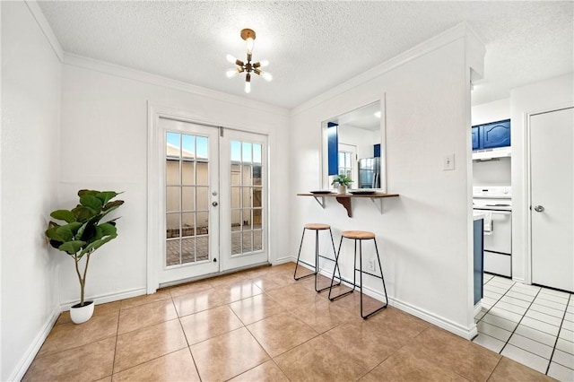 entryway with light tile patterned flooring, an inviting chandelier, a textured ceiling, and french doors