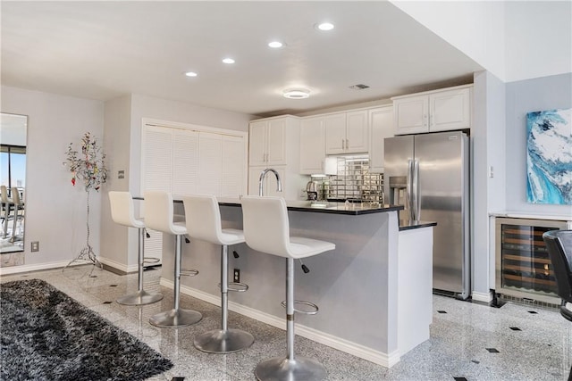 1400 Ocean Dr Unit 1104A, Corpus Christi, TX 78404 - kitchen with beverage cooler, stainless steel fridge, recessed lighting, white cabinets, and a kitchen breakfast bar