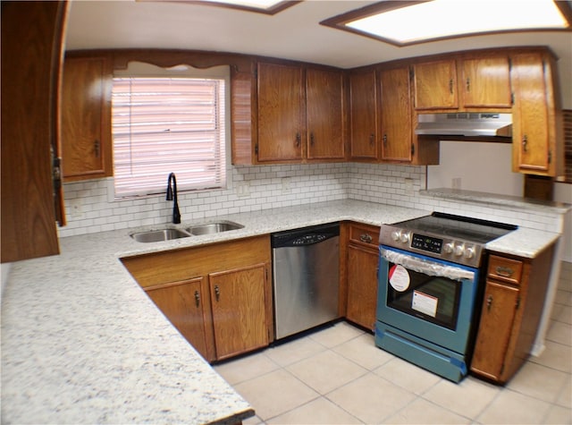 kitchen featuring appliances with stainless steel finishes, sink, backsplash, and light tile patterned flooring