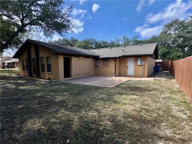 back of house featuring a patio area and a lawn