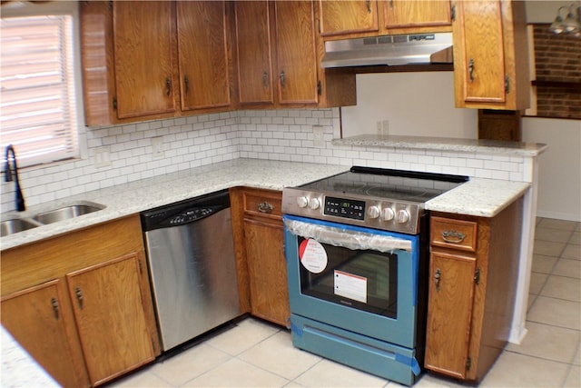 kitchen with decorative backsplash, stainless steel appliances, sink, and light tile patterned floors