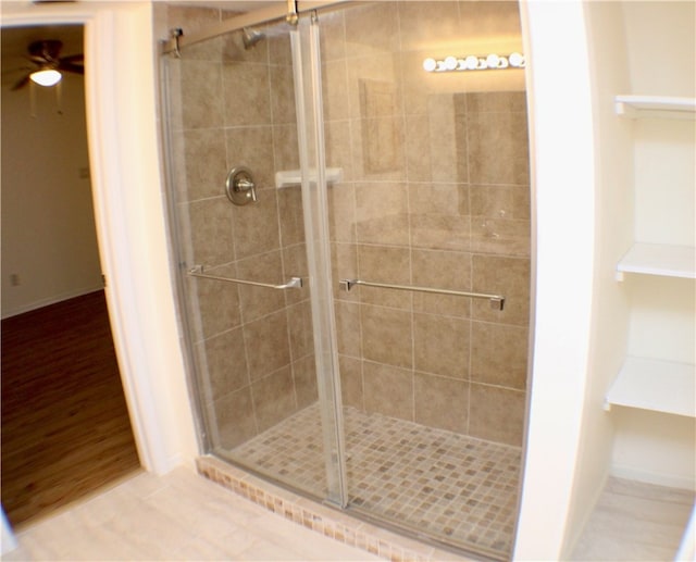 bathroom featuring hardwood / wood-style flooring, ceiling fan, and a shower with door