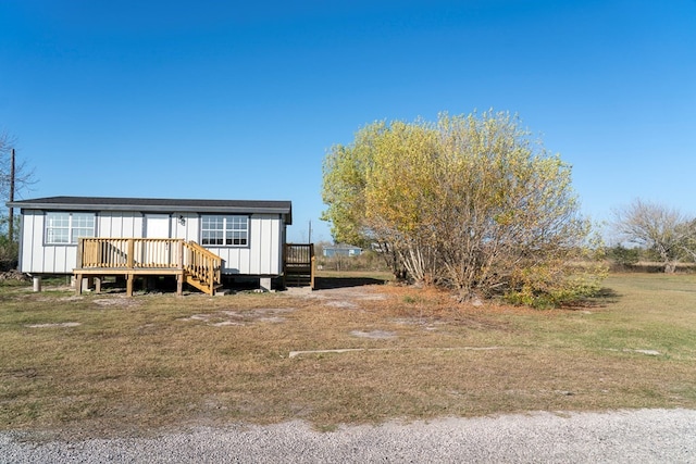 view of front facade with a deck and a front lawn