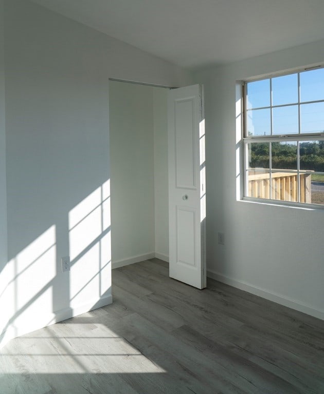 181 W Post Oak Ln, Rockport, TX 78382 - empty room featuring wood finished floors, baseboards, and lofted ceiling