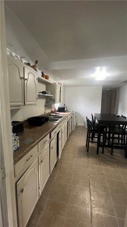 kitchen featuring white cabinets, tile patterned flooring, and sink