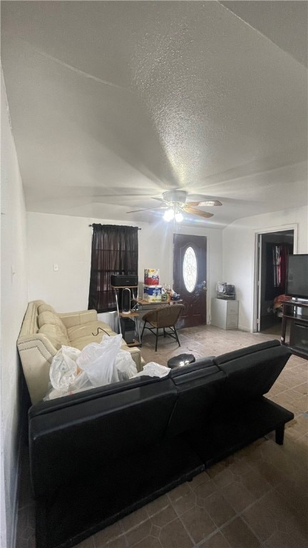 living room with ceiling fan, a textured ceiling, and lofted ceiling