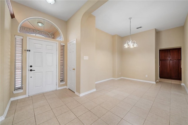 foyer entrance with an inviting chandelier, light tile patterned flooring, arched walkways, and visible vents