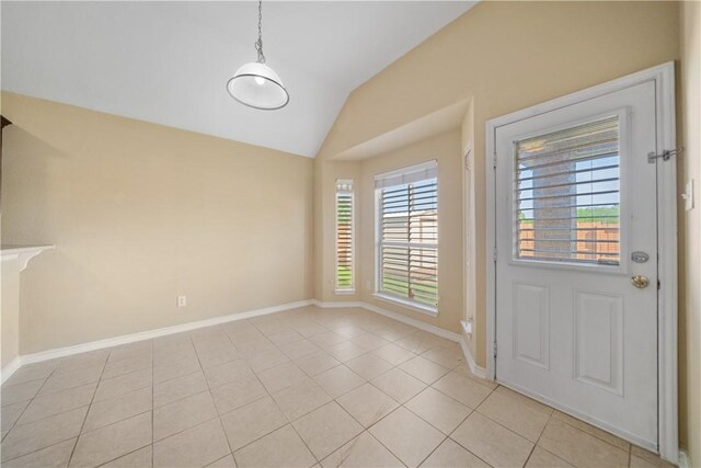 interior space with light tile patterned floors, baseboards, and vaulted ceiling