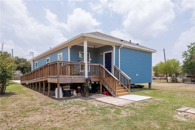 rear view of house with a lawn and a wooden deck