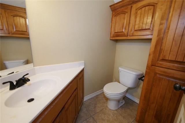 bathroom featuring toilet, tile patterned floors, baseboards, and vanity