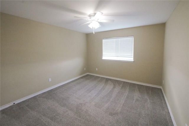 carpeted spare room featuring ceiling fan and baseboards