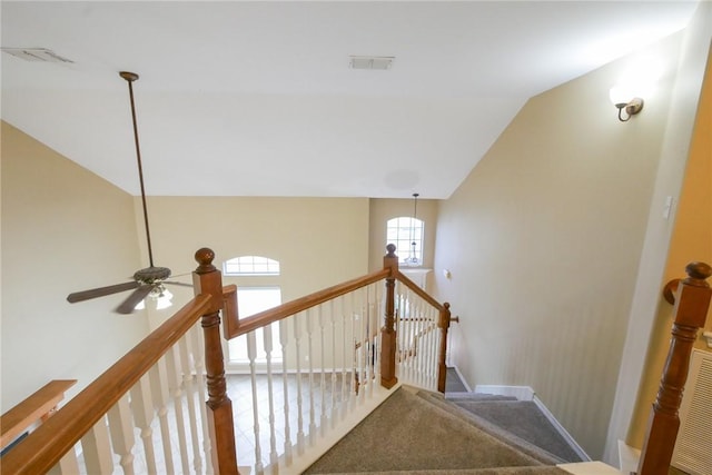 staircase with carpet floors, visible vents, baseboards, and vaulted ceiling