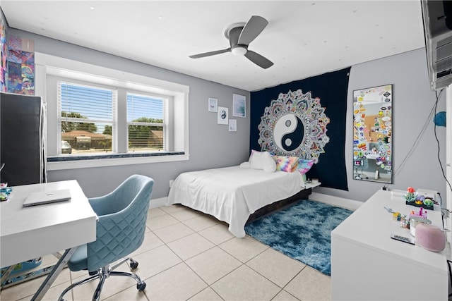 tiled bedroom featuring black fridge and ceiling fan