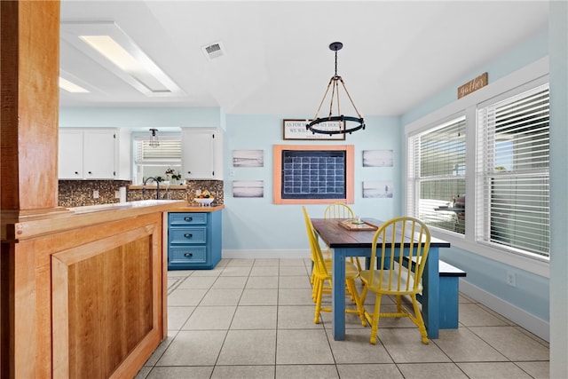 dining space featuring a notable chandelier and light tile patterned flooring