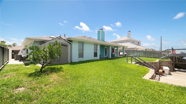 back of house with a patio area and a lawn