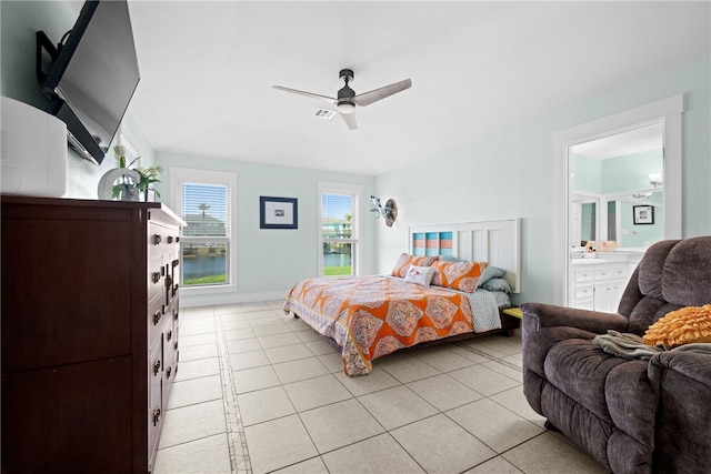 tiled bedroom with ceiling fan and ensuite bath