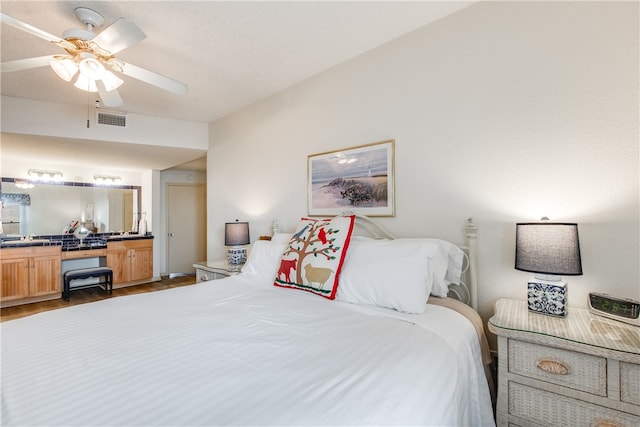 bedroom featuring dark wood-type flooring, ceiling fan, and a textured ceiling