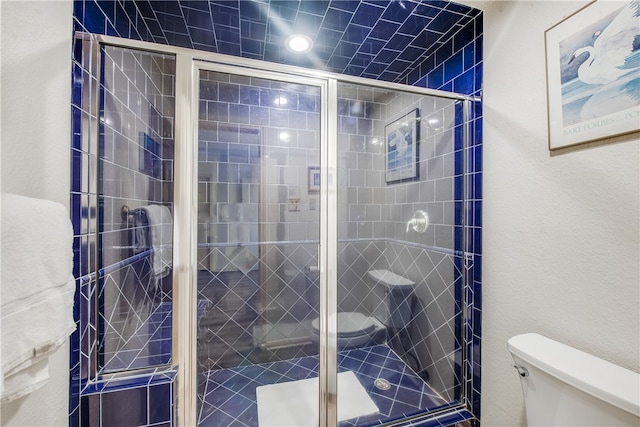 bathroom with an enclosed shower and toilet