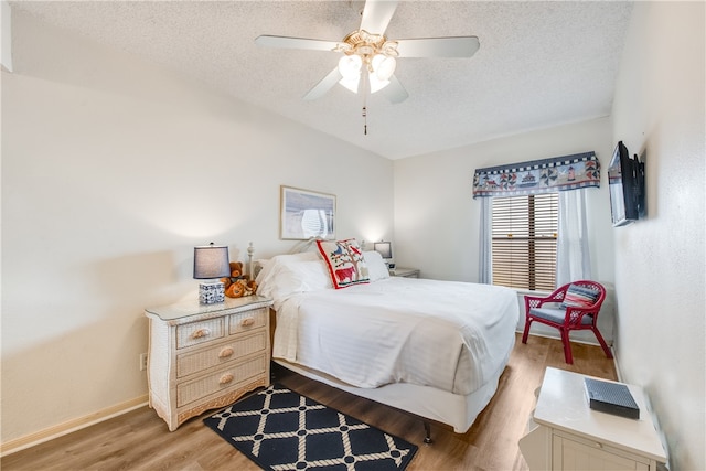 bedroom featuring wood-type flooring, ceiling fan, and a textured ceiling