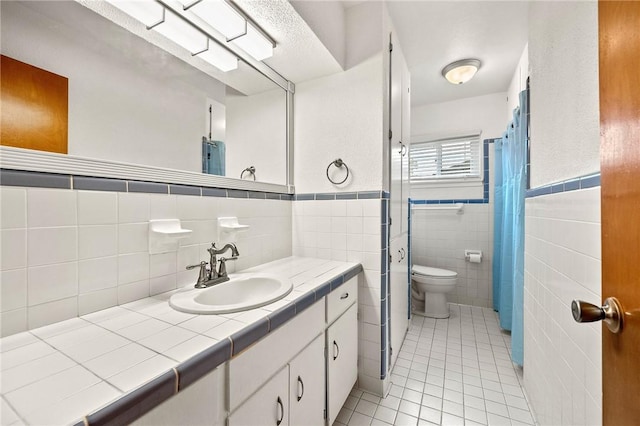 4414 Driftwood Pl, Corpus Christi, TX 78411 - bathroom featuring tile patterned flooring, vanity, toilet, tile walls, and wainscoting