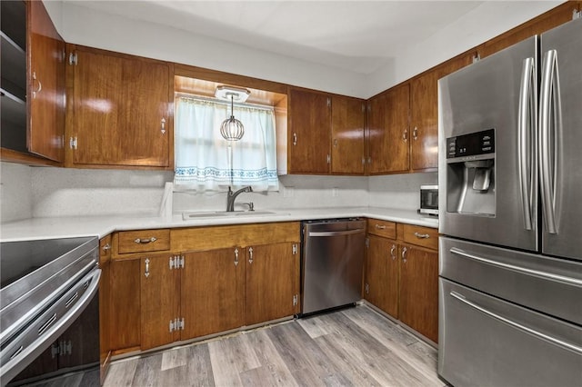 4414 Driftwood Pl, Corpus Christi, TX 78411 - kitchen with stainless steel appliances, a sink, light countertops, brown cabinets, and light wood-type flooring