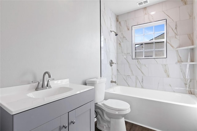 full bathroom featuring hardwood / wood-style flooring, vanity, toilet, and tiled shower / bath