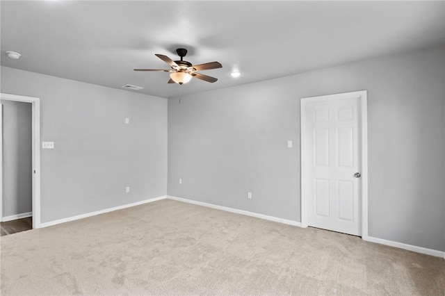 empty room featuring ceiling fan and carpet