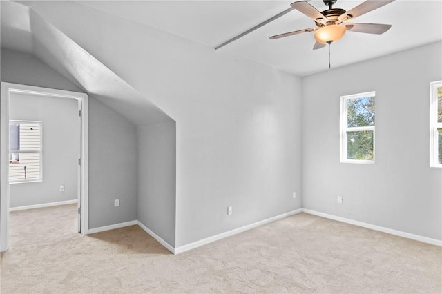 additional living space featuring ceiling fan, light colored carpet, and vaulted ceiling