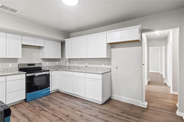 kitchen with light stone counters, light hardwood / wood-style flooring, white cabinetry, and electric stove