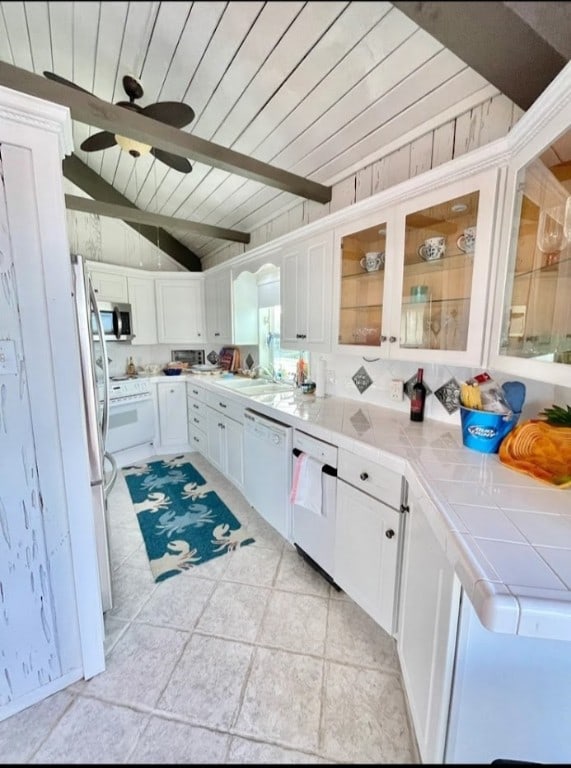 1878 Bay Shore Dr, Rockport, TX 78382 - kitchen with glass insert cabinets, tile counters, wooden ceiling, white cabinets, and white appliances
