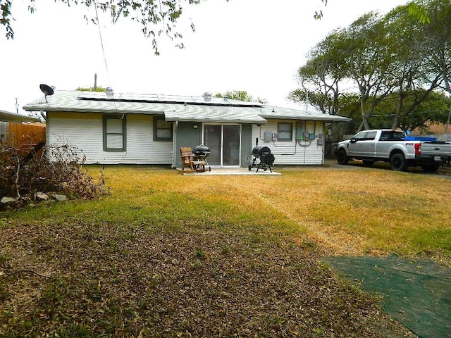 back of house featuring a patio area and a lawn