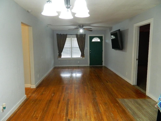 interior space with dark wood-type flooring and ceiling fan with notable chandelier