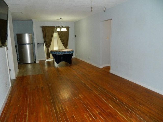 recreation room with dark wood-type flooring and an inviting chandelier