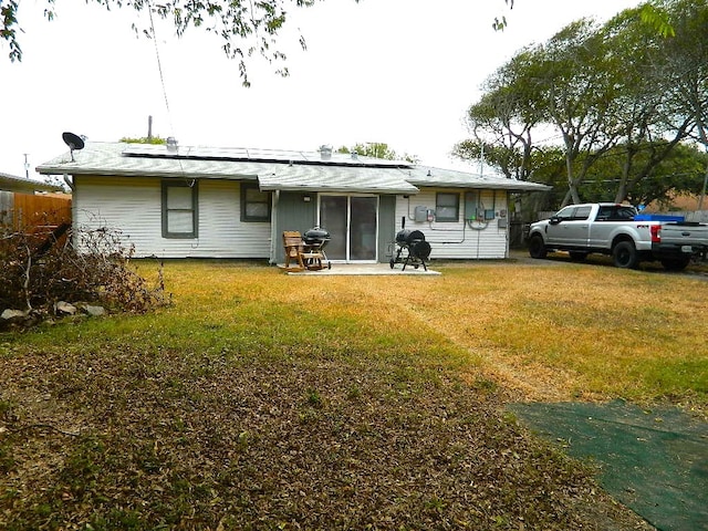 rear view of house featuring a patio and a lawn