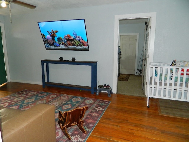 living room featuring hardwood / wood-style floors and ceiling fan