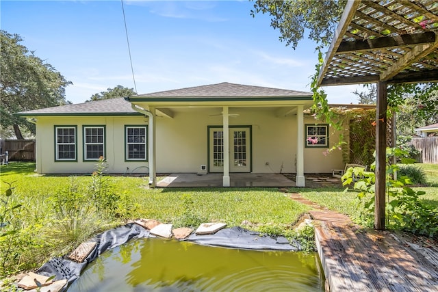 rear view of property featuring ceiling fan, a patio, a yard, a pergola, and french doors