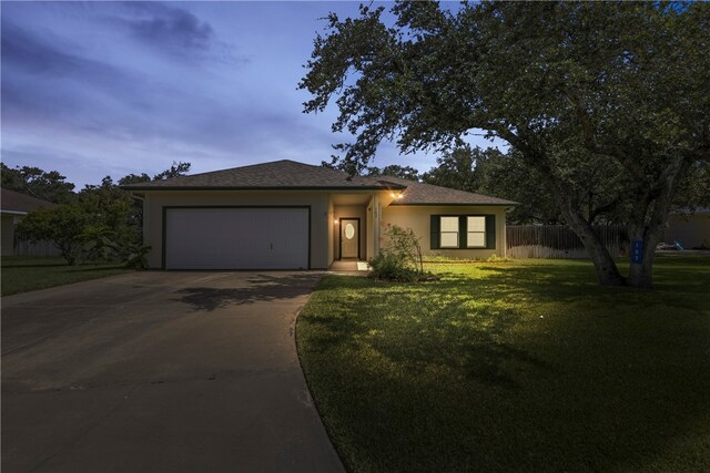 view of front of property featuring a garage and a yard