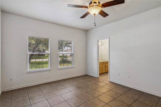 tiled spare room featuring ceiling fan