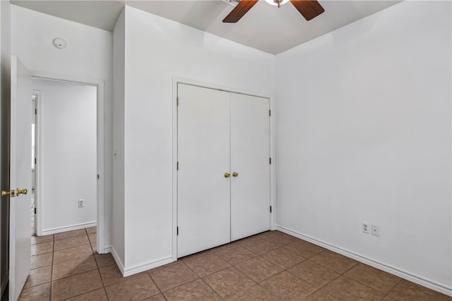 unfurnished bedroom featuring light tile patterned floors, ceiling fan, and a closet