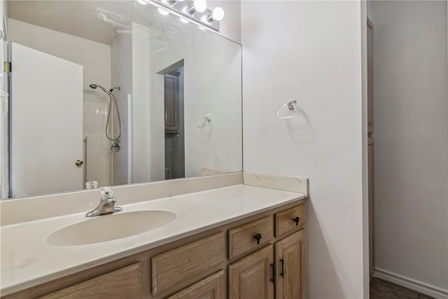 bathroom featuring a shower and vanity