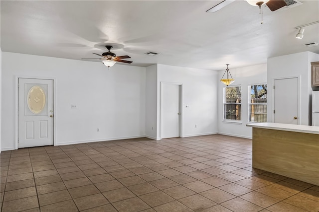 unfurnished living room featuring ceiling fan and tile patterned floors